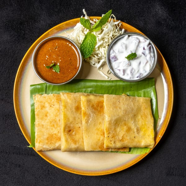 Anjappar Chettinad Indian Restaurant's dosa with two dipping sauces and shredded cabbage on a banana leaf.