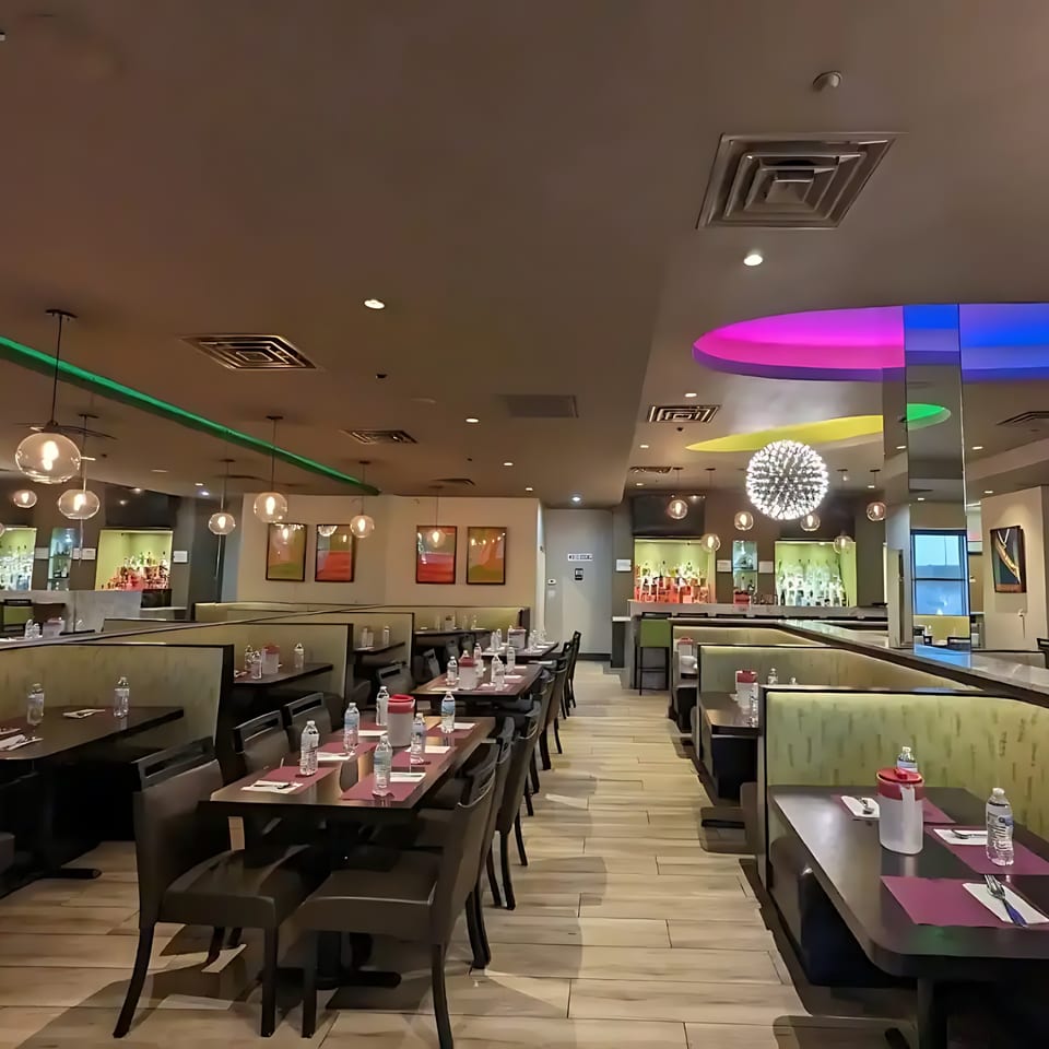 Anjappar Chettinad Indian Restaurant's dining room with tables, booths, and a bar area.